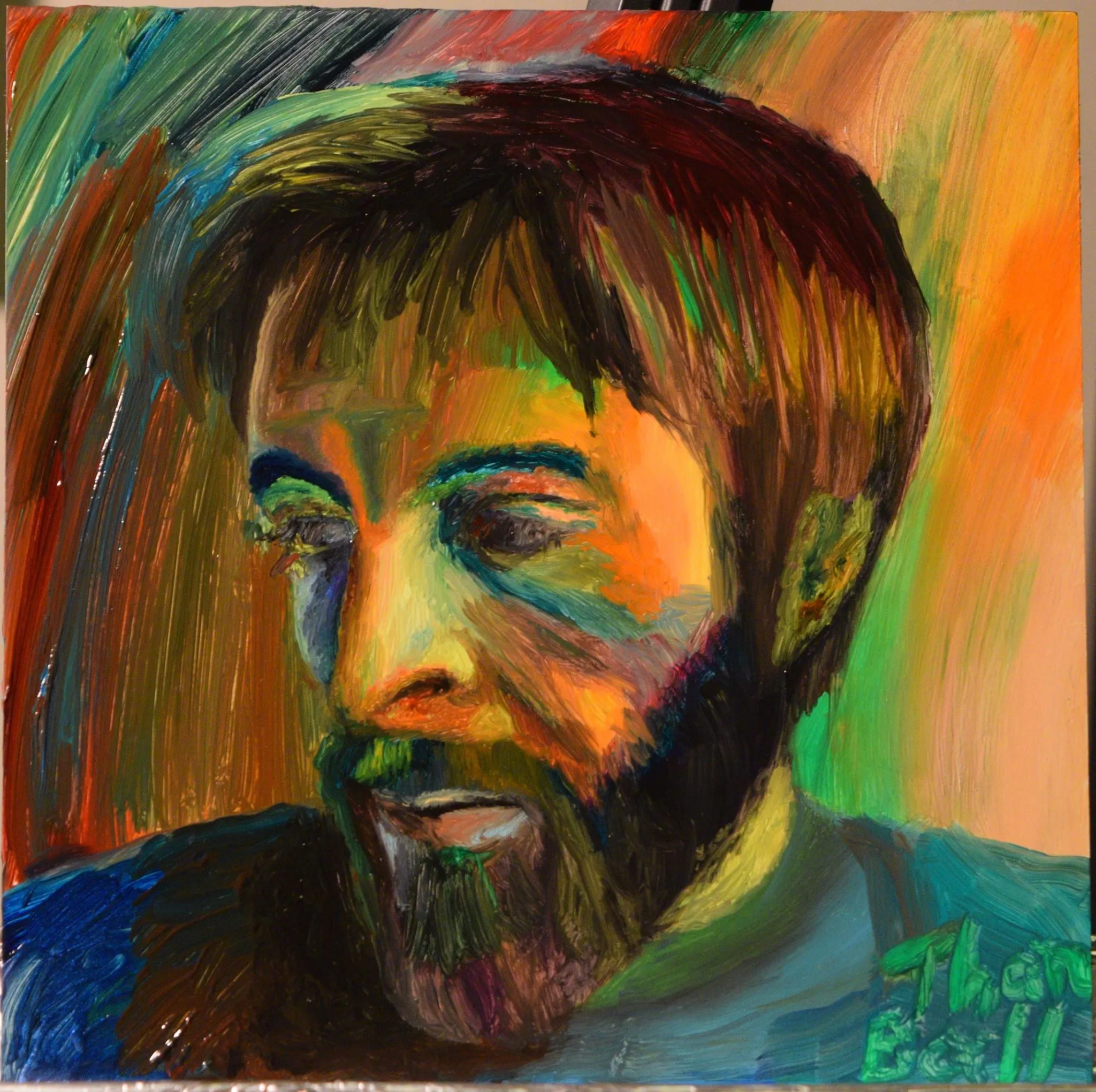 Colorful portrait of a bearded man looking down, painted in green, orange and blue
